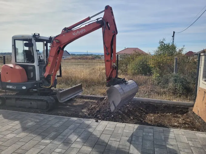 Kubota minikotró földmunkát végez egy kertben